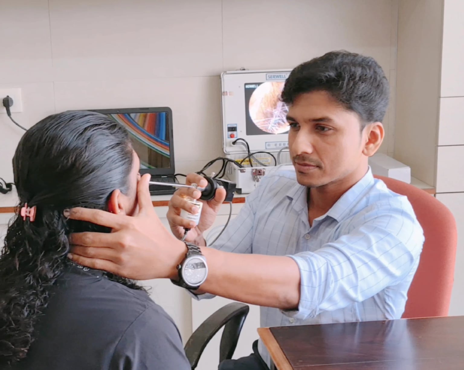 Dr. Rojan Ravi examining a patient during an ENT consultation